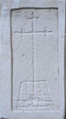 a cross carved into the side of a stone wall