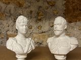 pair of white busts of two people on a wooden table