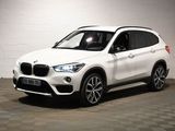 the white bmw suv is parked in a white room