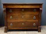 une commode ancienne dont les tiroirs sont ornés de ferrures en laiton