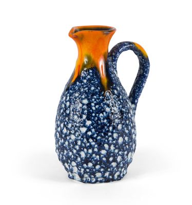 un vase orange et bleu orné de bulles, posé sur une surface blanche