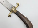 a close up of a knife with a wooden handle on a white surface