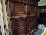 un grand meuble en bois dans le coin d'une pièce