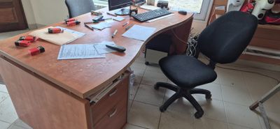 un bureau avec un ordinateur et une chaise devant une fenêtre