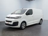 the white van is parked in a large room with a black floor
