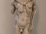 une statue représentant un homme barbu vêtu d'une cape