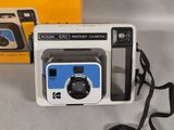 a polaroid camera sitting on a table next to a box