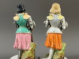 two figurines of a woman and a man dressed in medieval clothing