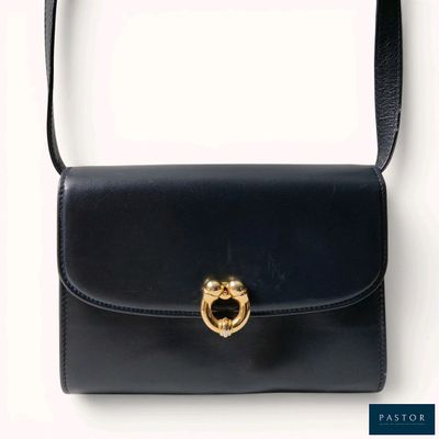 black leather handbag with a gold metal ring on the handle