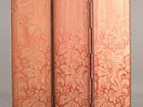 a red and gold room divider screen with a floral design