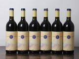 six bouteilles de vin sont alignées sur une table en bois