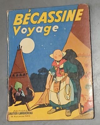 La couverture du livre *Becassine voyage* est posée sur une table.