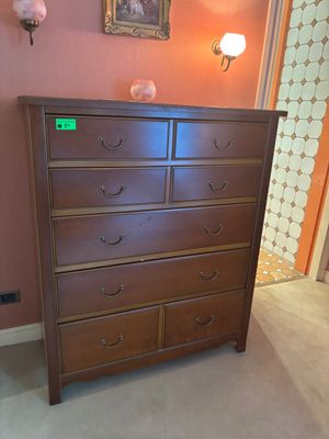 une commode marron dans un coin de la pièce