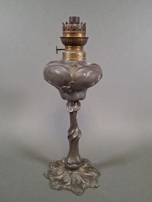 une lampe à huile ancienne en verre argenté, surmontée d'une couronne