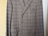 grey and pink checkered jacket hanging on a hanger in front of a door