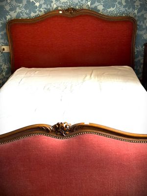 a bed that has a red headboard and a red foot board