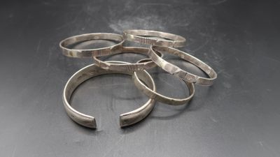 a close up of a bunch of silver rings on a table