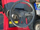 a red tractor with a steering and a box of wood