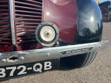 a close up of a red and black car with a number plate on it