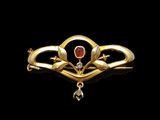 an image of a gold and garnet stone broochle