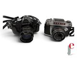 two cameras sitting next to each other on a white surface