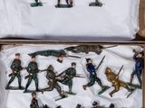 many figurines of soldiers in a cardboard box