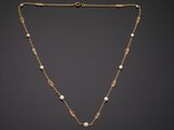 a gold necklace with pearls on a chain