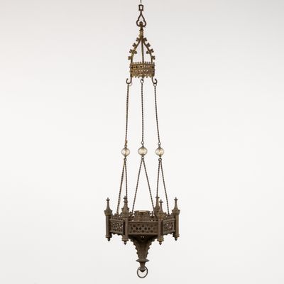 an antique brass hanging light fixture with a chain and a light bulb
