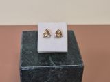 a close up of a pair of earrings sitting on top of a marble block