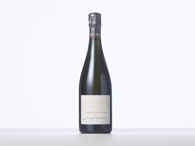 une bouteille de vin posée sur une table blanche