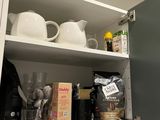 a kitchen cupboard with a lot of items in it