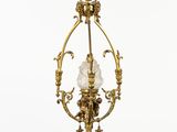 un lustre ancien en laiton, muni d'un abat-jour en verre, suspendu au plafond