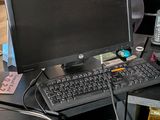 a desk with a computer, phone, and other electronics on it