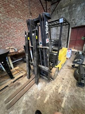 un chariot élévateur dans un entrepôt où se trouvent de nombreuses palettes