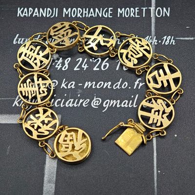 un bracelet en or orné d'inscriptions et de symboles chinois