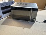 a microwave that is sitting on a counter next to a box