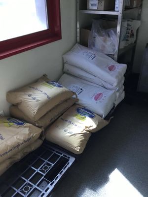 bags of rice sitting on a shelf next to a window