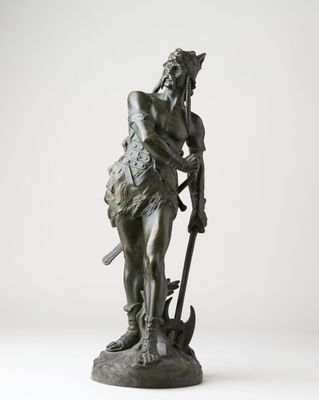 a bronze statue of a man holding a spear and a hammer