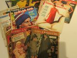 beaucoup de magazines posés sur une table à côté d'une lampe