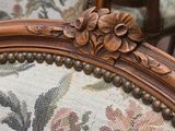 a close up of a chair with a flower design on it
