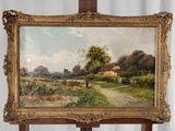 un tableau posé sur un chevalet, avec, en arrière-plan, un tableau représentant une maison