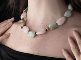 woman wearing a black top and a pink necklace with green beads