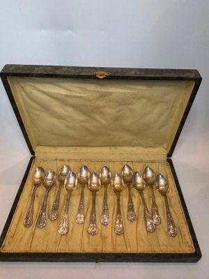 six silver spoons in a black case on a table