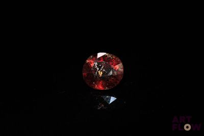 a close up of a red diamond on a black surface
