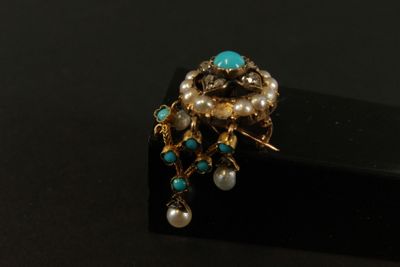 une image représentant une bague ornée de perles et de pierres de turquoise sur un fond noir
