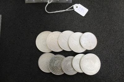 beaucoup de pièces d'argent sur la table, à côté d'un sac d'argent