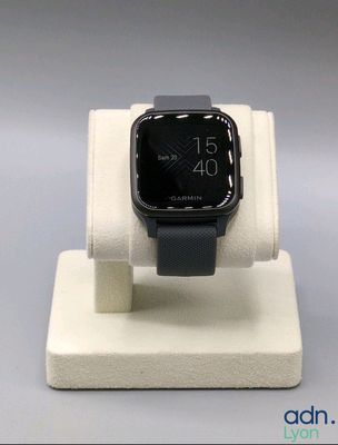 une montre connectée posée sur un socle, sur une table