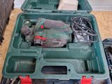 a green tool box with tools in it on the floor
