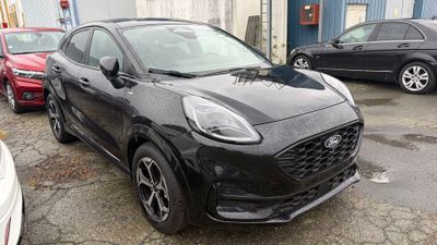 l'avant d'une voiture noire garée sur un parking à côté d'autres voitures
