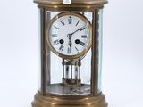 une horloge en or avec des chiffres romains, dans une vitrine